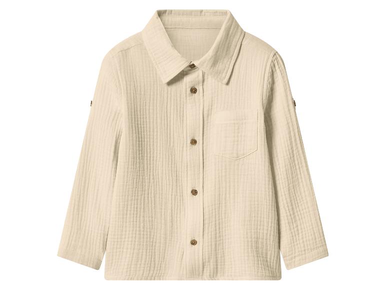 Chemise crème à manches longues avec boutons marrons et poche poitrine.