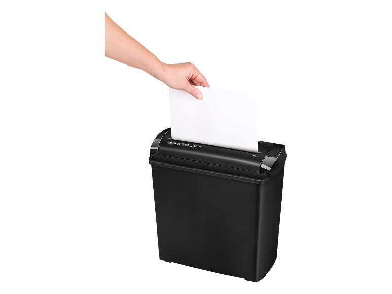 Main insérant une feuille de papier blanche dans un destructeur de documents noir