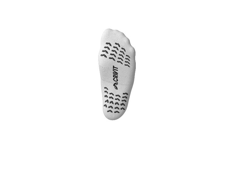 Chaussette antidérapante blanche avec semelle noire à motifs.