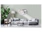 Un canapé gris avec des coussins, une table basse et un cadre photo avec l'inscription 'Live Laugh Love'.