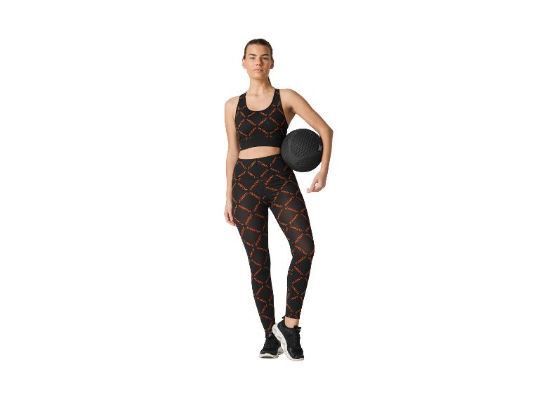Femme en brassière de sport et legging noirs CRIVIT avec un medecine-ball.