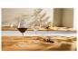 Verres à vin avec du vin rouge et un tire-bouchon sur une table en bois dans une cuisine.
