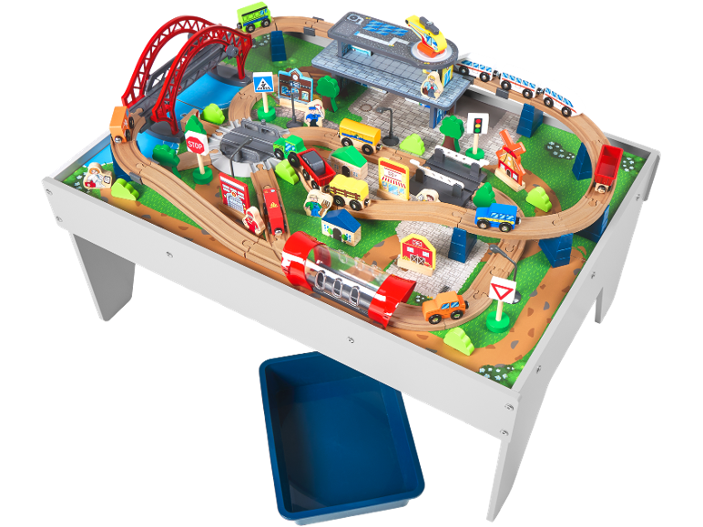 Ensemble de train en bois sur table de jeu avec pont, gare, véhicules et figurines.