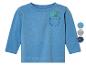 Un t-shirt bleu clair à manches longues pour bébé avec un dinosaure brodé sur la poche poitrine.