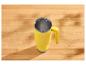 Mug thermique jaune avec anse sur une table en bois avec des motifs d'ombre.
