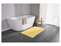 Une baignoire et un tapis de bain jaune dans une salle de bain.