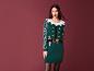 Une femme portant un pull de Noël vert avec un motif d'elfe.