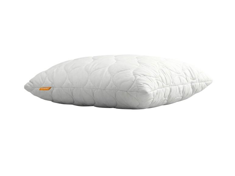 Oreiller matelassé blanc avec une étiquette orange sur le côté