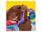 Mains d'enfant coupant de la pâte à modeler marron avec des ciseaux violets, entourées d'outils de jeu colorés.