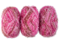 Trois pelotes de fil rose et marron avec des reflets brillants.