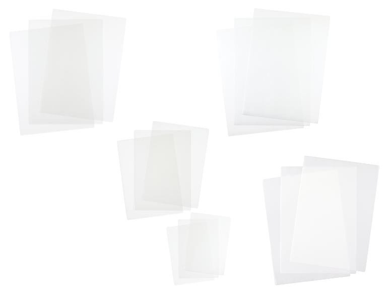 Plusieurs piles de feuilles de plastique transparent ou de protège-documents sur fond blanc.