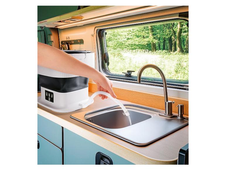 Machine à laver portable vidant l'eau dans un évier de camping-car.