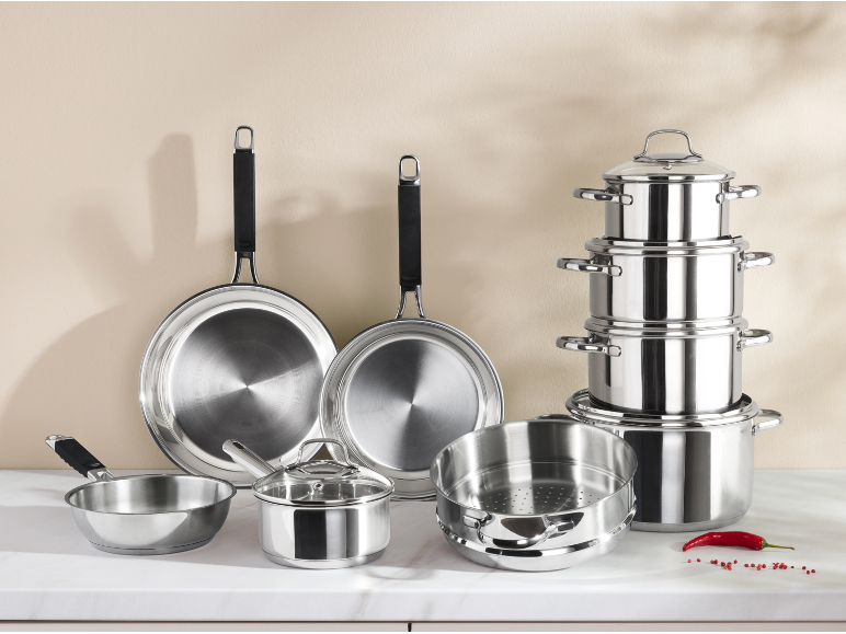 Un ensemble complet de casseroles et de poêles en acier inoxydable sur un plan de travail.
