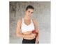 Une femme en vêtements de sport utilise un pistolet de massage sur son bras.