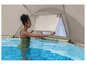 Une femme dans une piscine avec un abri de piscine gonflable