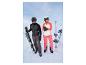 Un homme et une femme en vêtements de ski avec des skis et des bâtons dans la neige.