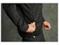 Un homme portant un sweat-shirt noir à fermeture éclair et un pantalon noir.