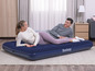 Un couple se repose sur un matelas pneumatique Bestway.