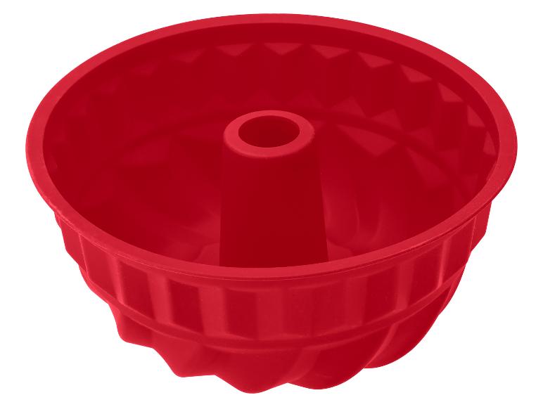 Moule à gâteau bundt en silicone rouge avec un motif cannelé.