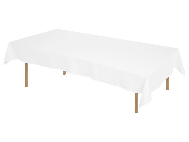 Nappe blanche sur table rectangulaire en bois.