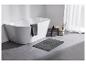Baignoire moderne, tapis de bain gris et accessoires de salle de bain.