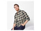 Homme en chemise à carreaux et jeans.