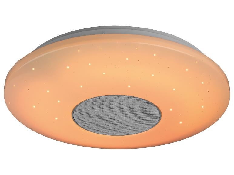 Plafonnier rond avec haut-parleur intégré et effet d'étoiles, éclairé chaleureusement.