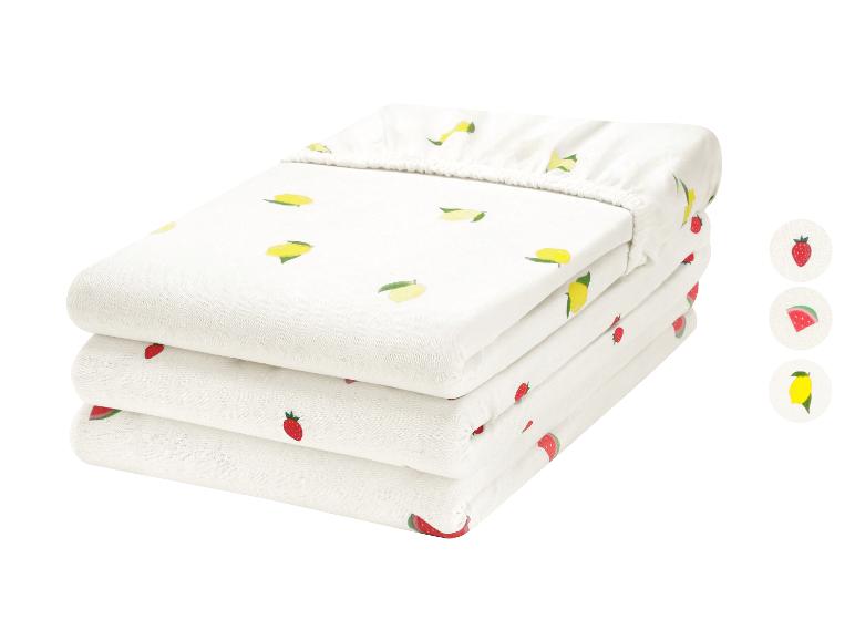 Pile de trois draps-housses blancs avec motifs de fruits : citrons, fraises et pastèques.