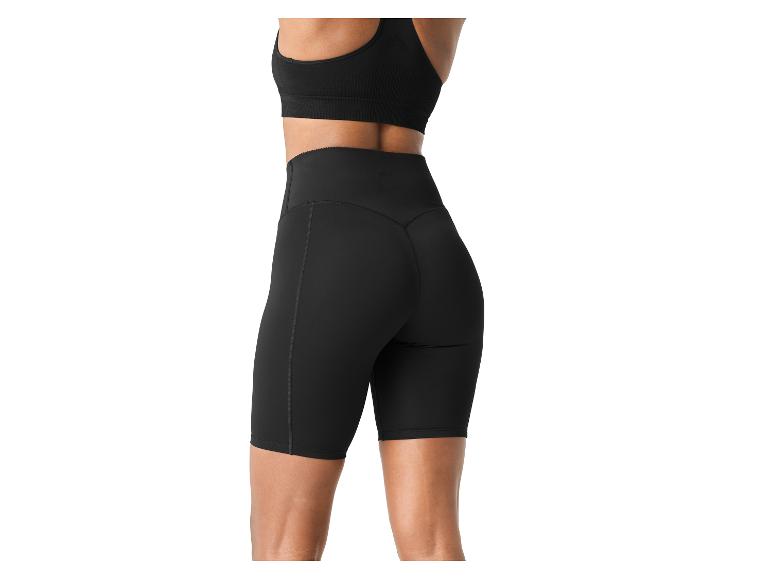 Femme en short cycliste noir et brassière de sport noire, vue de dos