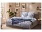 Chambre à coucher avec parure de lit à motif tropical, jeté de lit bleu et art mural.