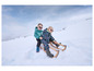 Deux enfants sur une luge dans la neige.