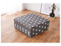 Un matelas pliable gris avec des étoiles blanches.