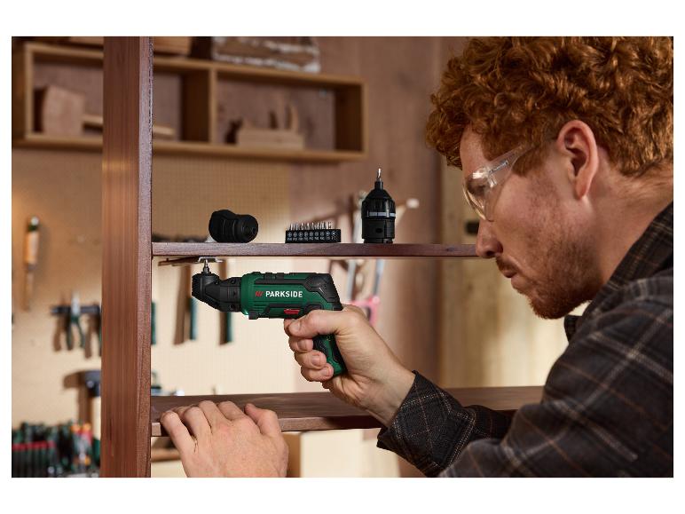 Homme utilisant le tournevis sans fil PARKSIDE 4 V pour assembler une étagère en bois.