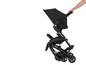 Une poussette Maxi-Cosi noire avec un mécanisme pliable.