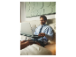 Un homme travaille sur son ordinateur portable au lit.