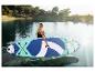 Femme avec une planche de paddle sur un lac, entourée d'arbres.