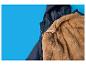 Une veste d'hiver bleu foncé avec une doublure en fausse fourrure marron sur fond bleu.