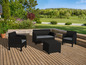 Un salon de jardin en osier noir avec deux fauteuils, une causeuse et une table basse sur une terrasse en bois.