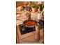 Préparation d'une sauce tomate ; moulins à poivre en bois.
