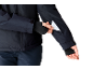 Personne en veste bleu foncé et gants sortant une carte blanche de la poche de la manche.