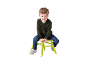 Garçon souriant aux cheveux bouclés assis sur un tabouret vert.