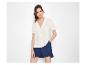 Femme en chemise blanche à manches courtes et short bleu.