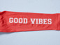 Un t-shirt rose avec l'inscription 'Good Vibes'.