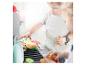Enfants jouant avec un barbecue jouet et de la nourriture en feutre, dont un hamburger et des légumes.