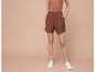 Une femme portant un short marron et des baskets blanches.