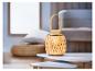 Une lampe en bois avec un abat-jour en rotin sur une table basse