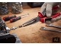 Pince à bec demi-rond tenant un ressort sur un établi avec des outils.