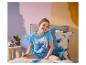 Fille en pyjama à thème extraterrestre, assise sur le lit avec une peluche.