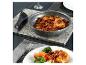 Poulet et haricots mijotés dans une poêle, servis avec des légumes.