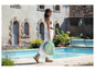 Une femme avec une piscine gonflable Bada Bülle au bord de la piscine.